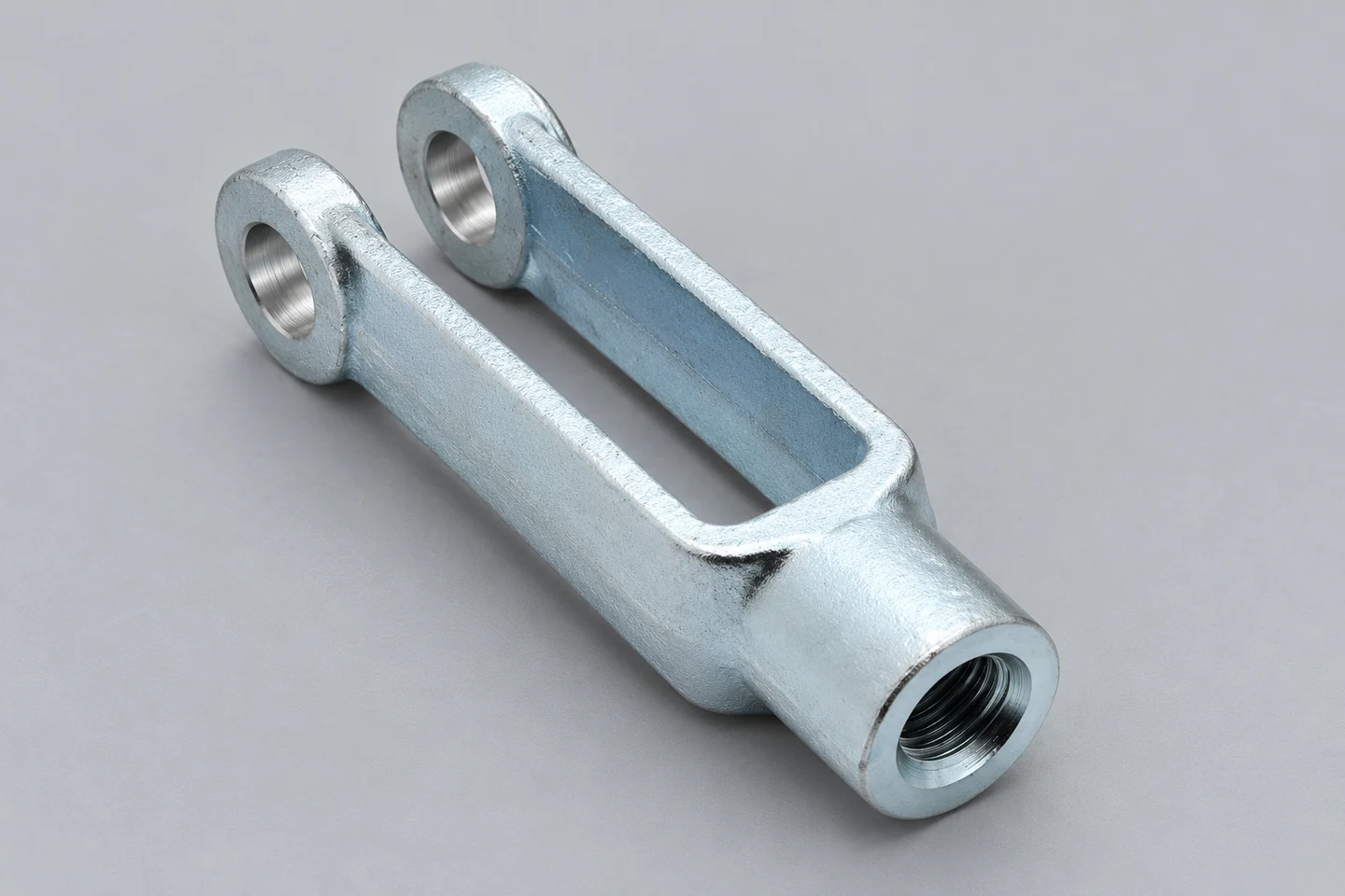 Clevis geometry with paired bores and a threaded connection.